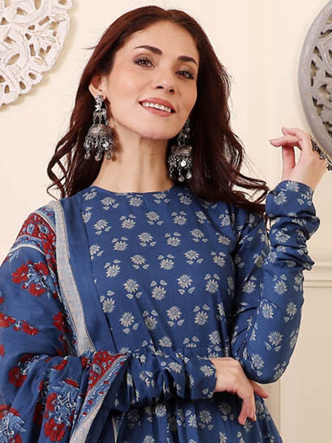 Woman wearing a blue floral dress with a decorative background