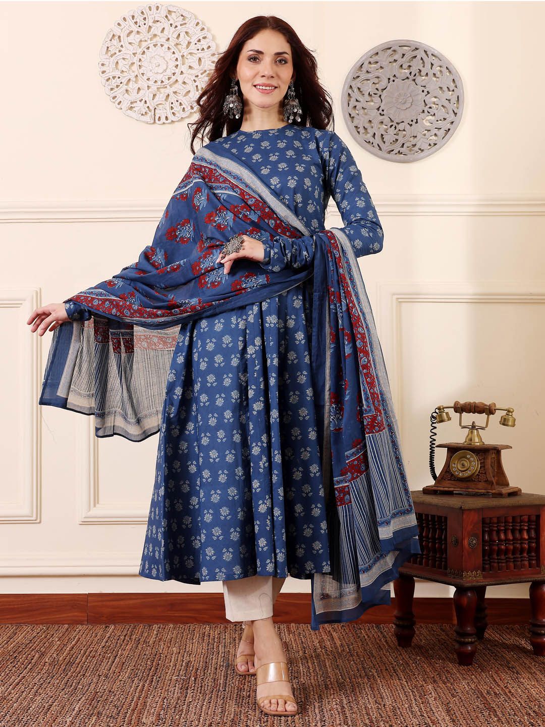 Woman wearing a blue traditional outfit with a matching dupatta in an elegant room.