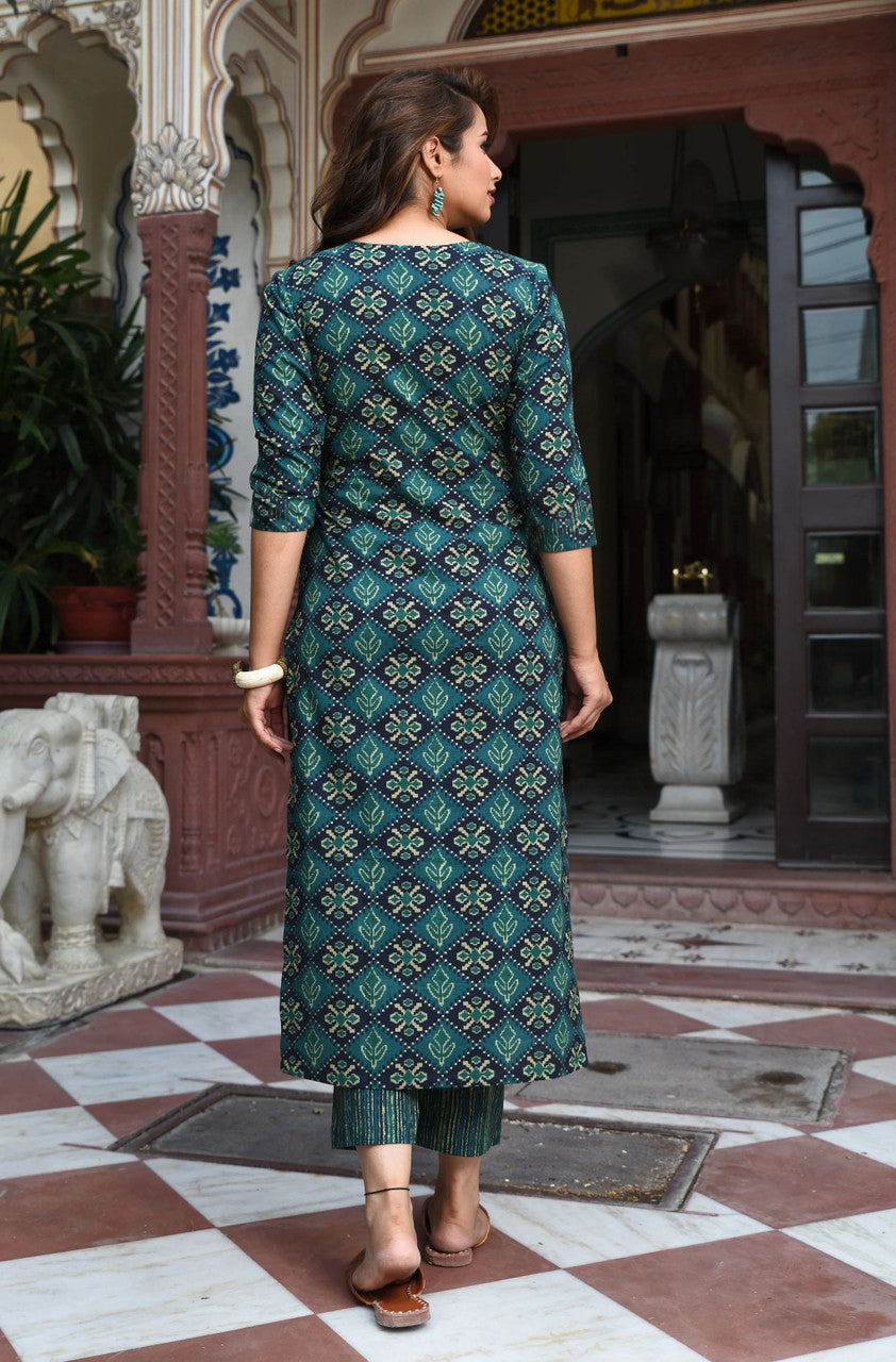Woman wearing a green patterned kurta standing in an outdoor setting with architectural elements.