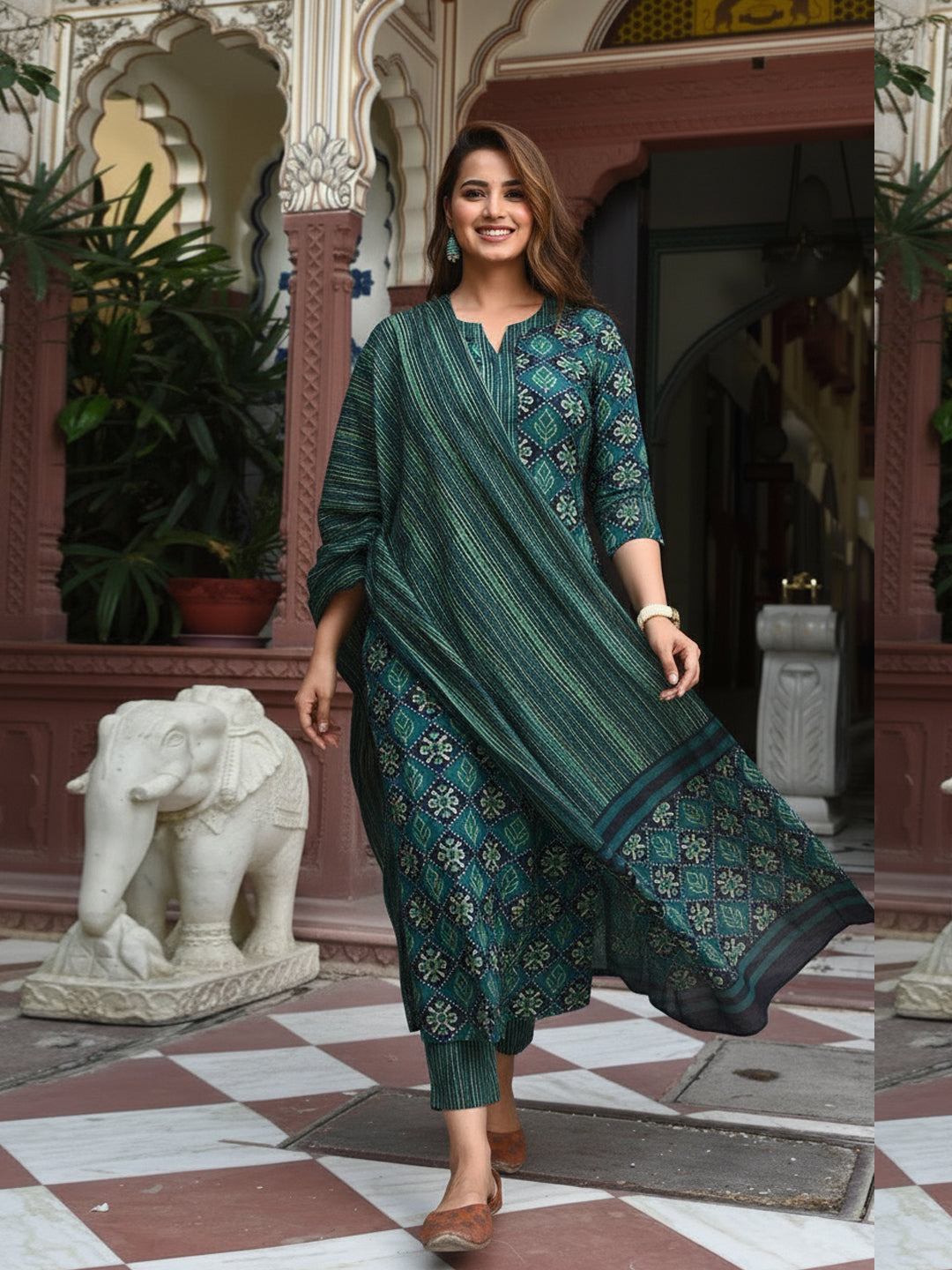 Woman in a green traditional outfit standing in an ornate indoor setting with decorative elements.