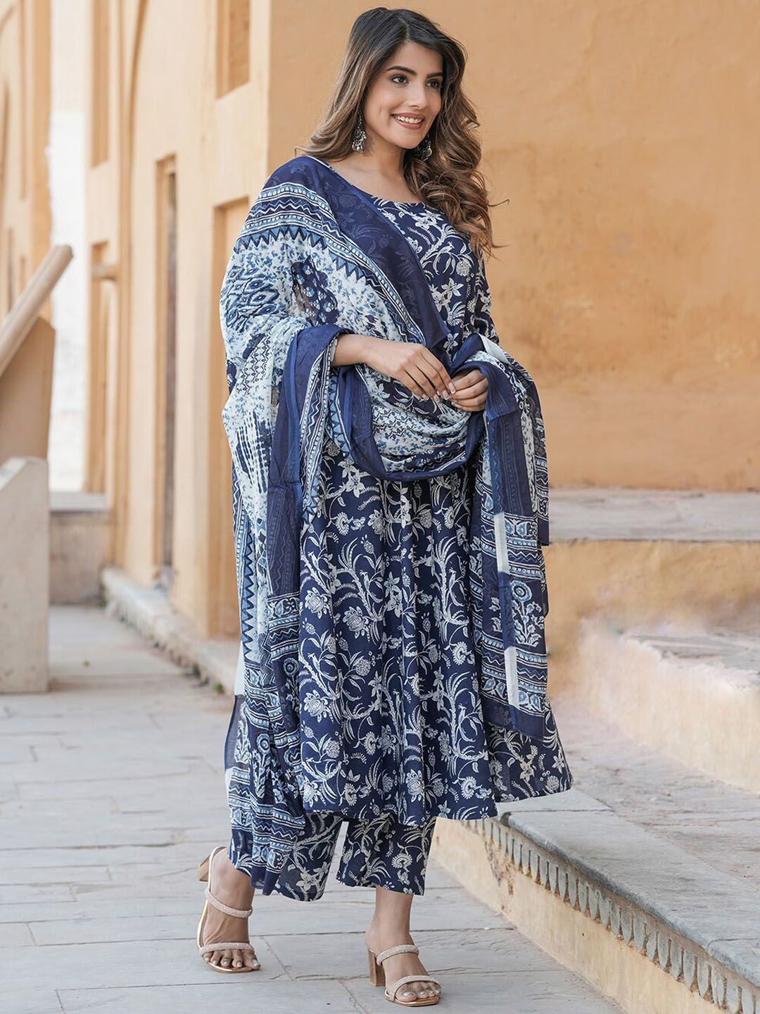 Woman wearing a blue and white patterned outfit standing outdoors.
