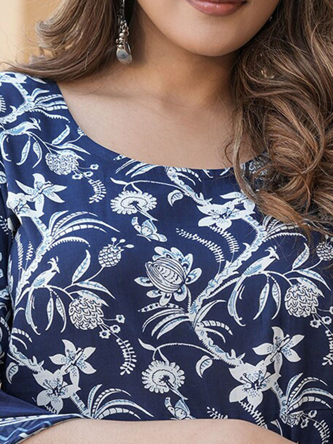 Navy blue top with white floral and peacock pattern worn by a person