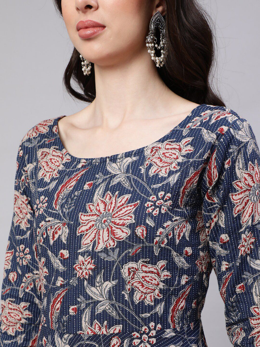 Woman wearing a blue floral dress with a gray background