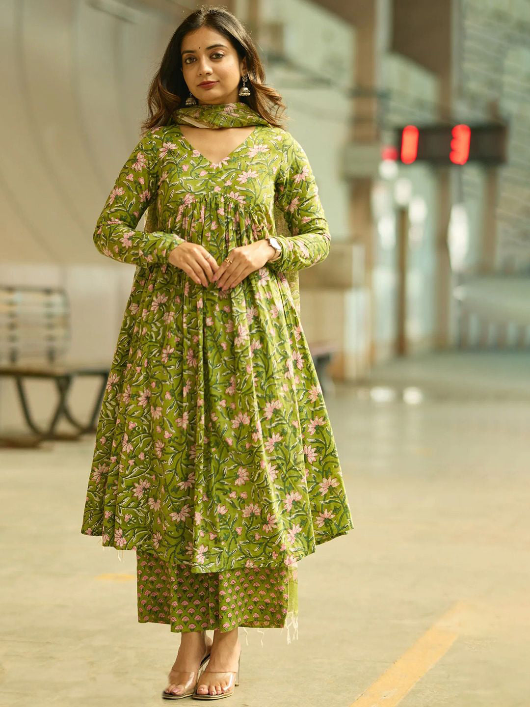 Woman wearing a green floral dress in an urban setting