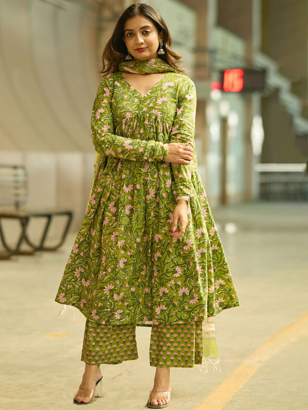 Woman wearing a green floral dress in an indoor setting