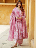 Woman wearing a pink and white traditional outfit with a dupatta in an outdoor setting.
