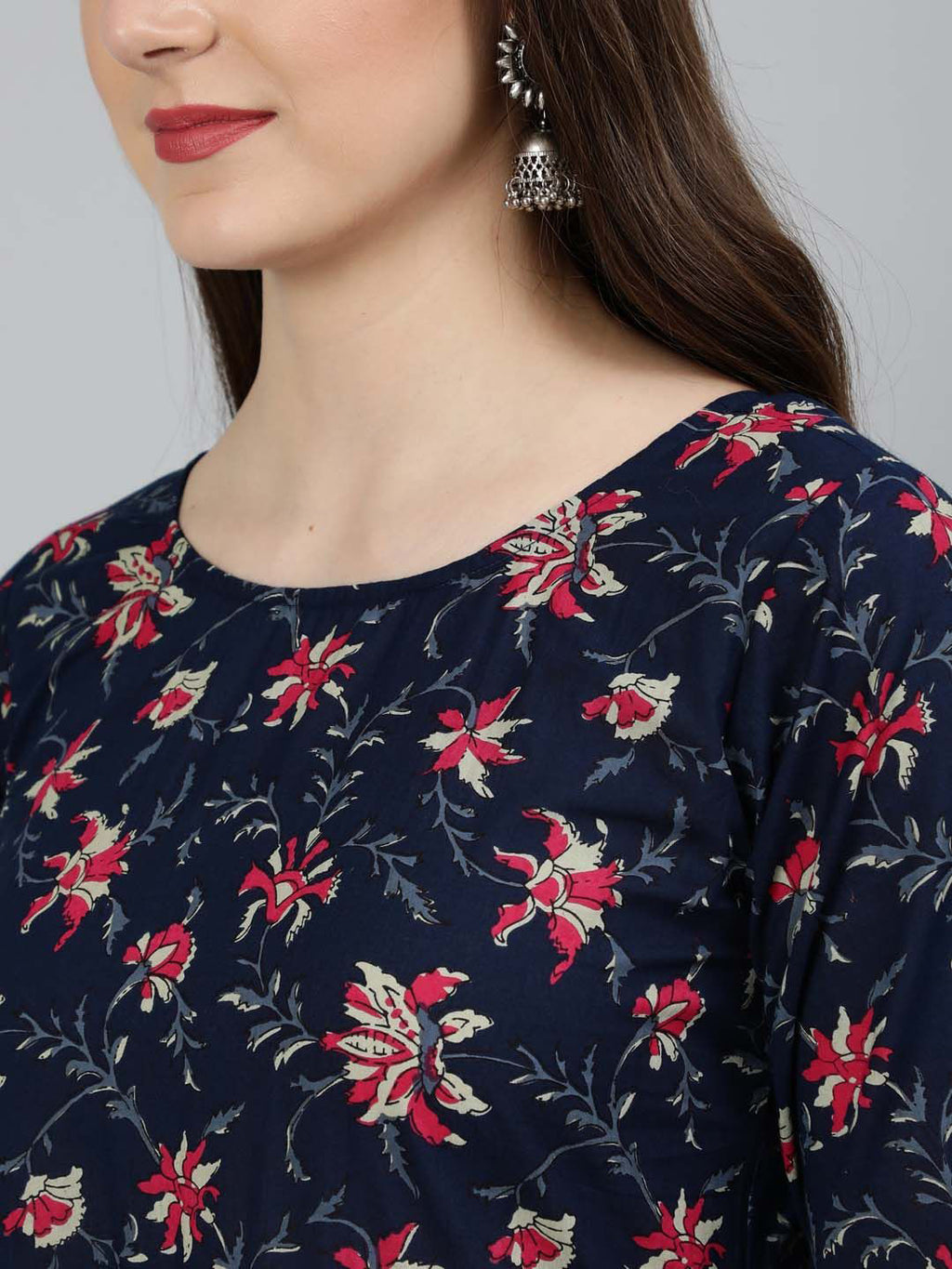 Navy blue top with red floral pattern worn by a person against a gray background
