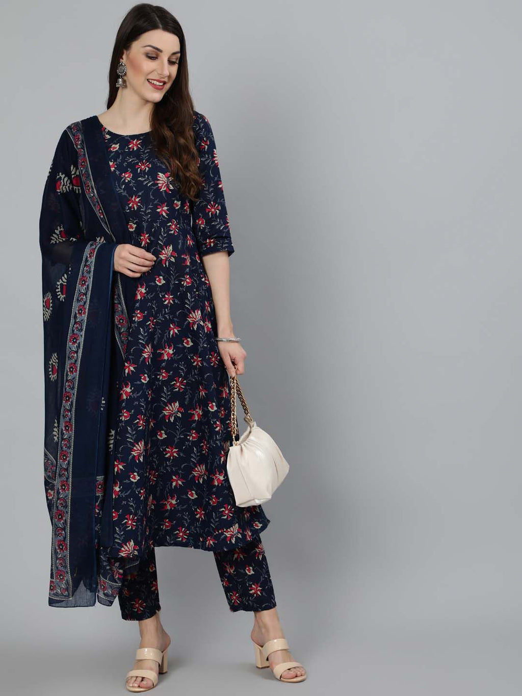 Woman wearing a navy blue floral dress with matching dupatta on a gray background