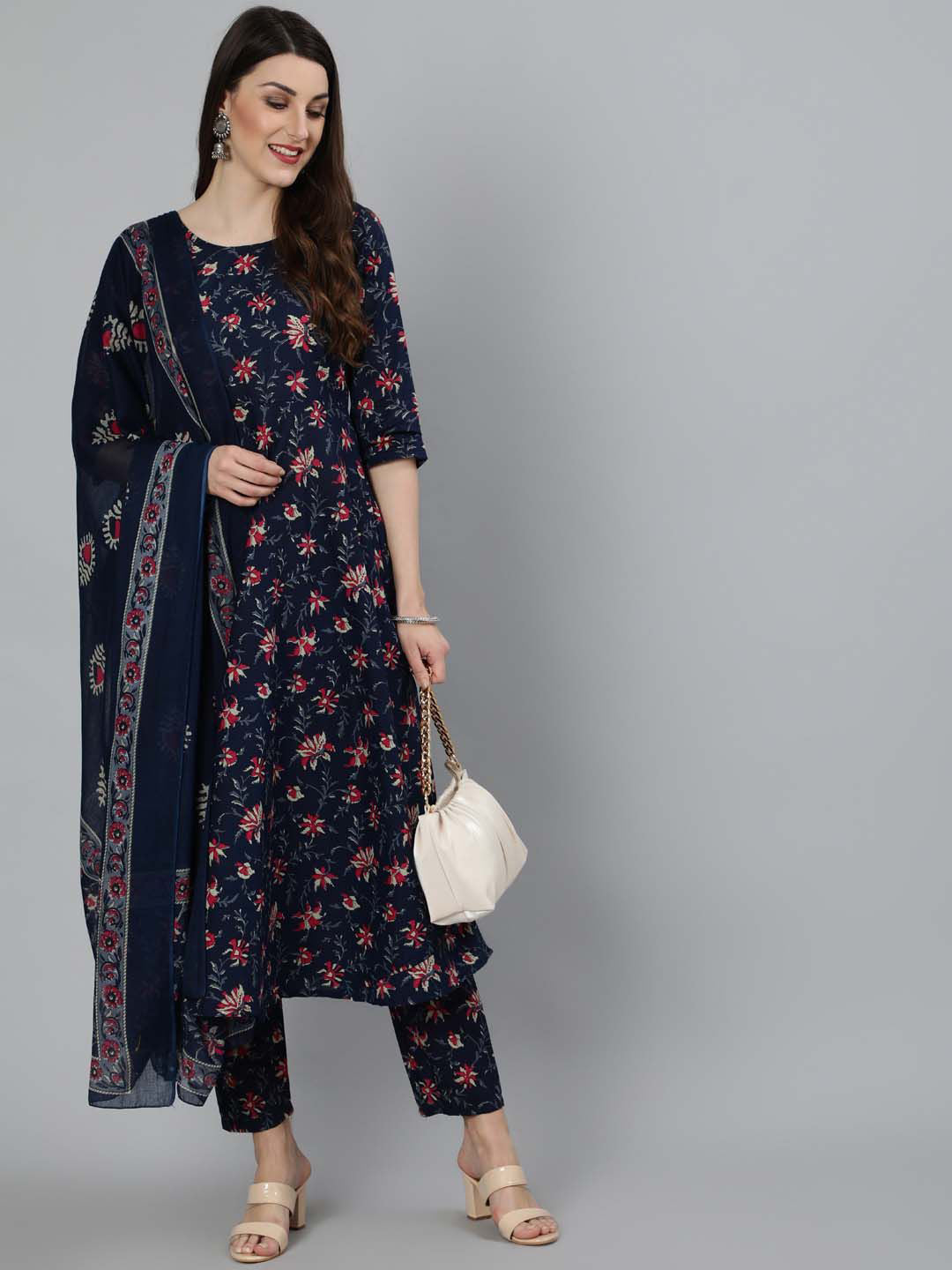 Woman wearing a navy blue floral dress with matching dupatta on a gray background